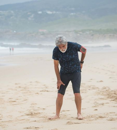 Man stretching outdoors, feeling energized by the morning sun.